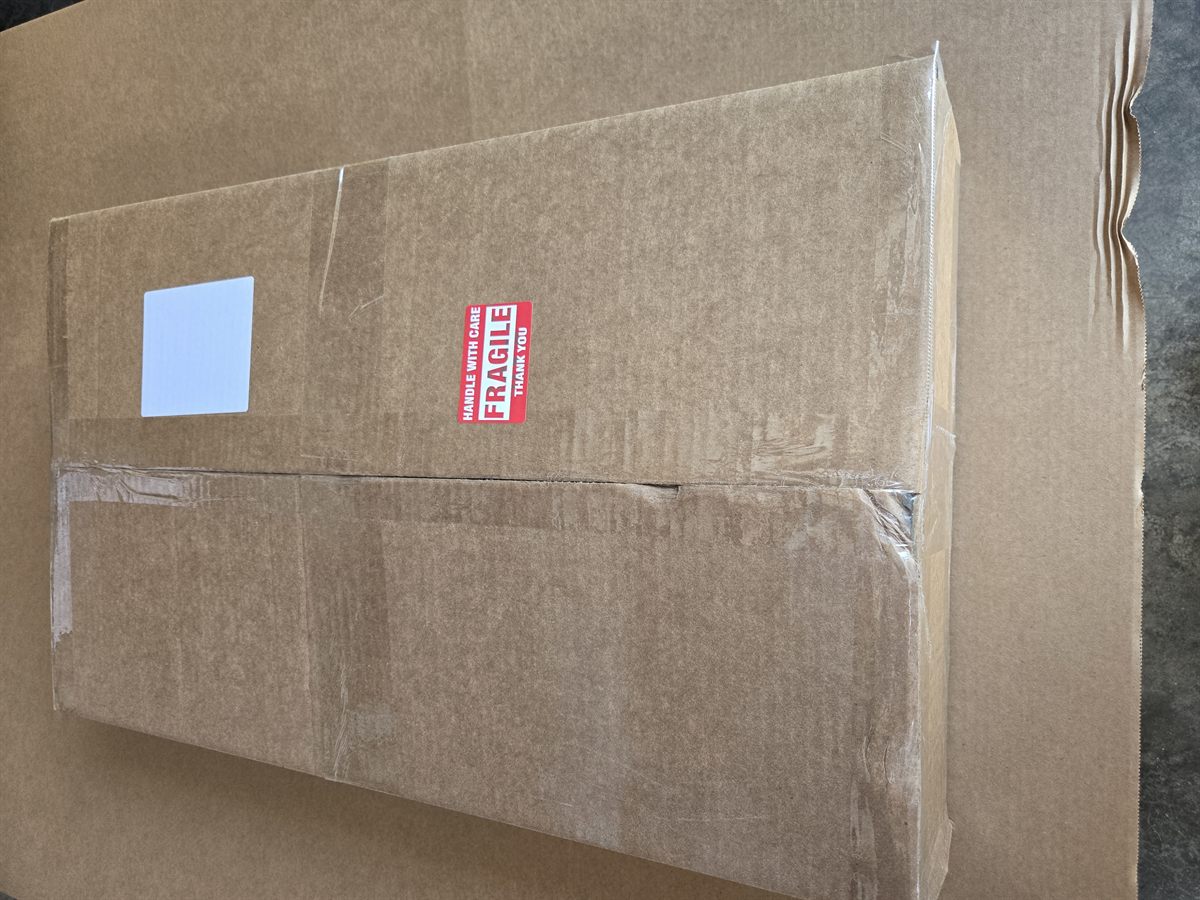 Sealed Theo's Farm shipping box with fragile handle with care label